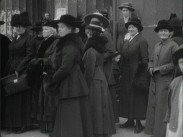 En samling kvinnor på trottoaren framför kanslihuset i Stockholm i samband med en kvinnorösträttdeputation hos statsministern 1917.