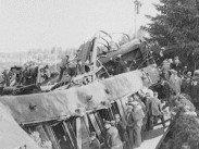 Stillbild från filmen Bollnäsolyckan 1928 som visar en stor samling människor som tittar på det kraschade tåget.