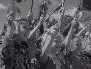 Leende barn i skolåldern viftar med svenska flaggor.