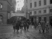 Julmarknad på Västerlånggatan i Stockholm, december 1926. Folk i rörelse, barmark.