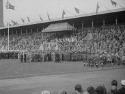 Mängder av människor med fanor på plan och läktare på Stadion i Stockholm under firandet av Svenska Flaggans dag 1930.