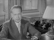 Dag Hammarskjöld tittar in i kameran sittandes vid skrivbord.