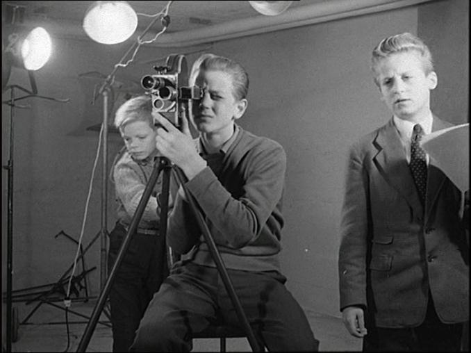 Tre ungdomar under en filminspelning, fotografen med en 16mm-kamera i mitten.