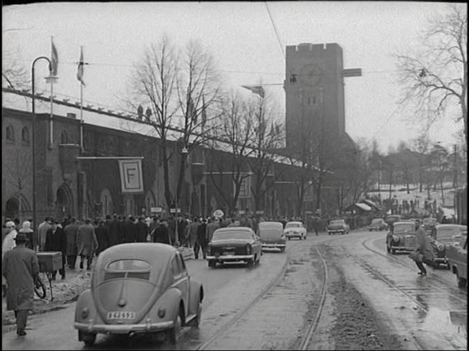 Bilar och fotgängare utanför Stockholms stadion inför SM-finalen i bandy 1960.